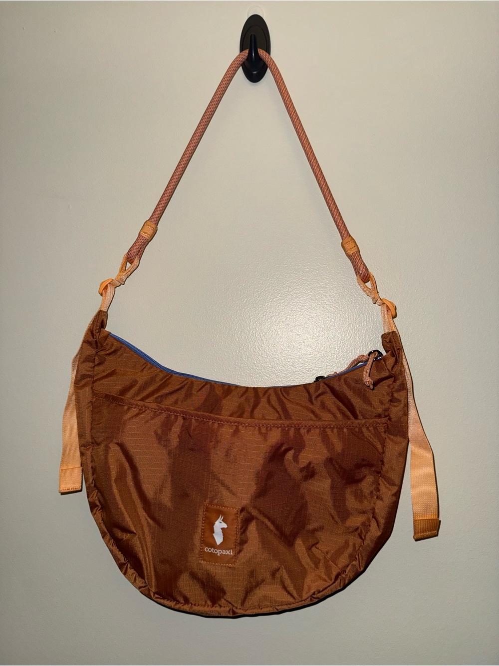 cotopaxi rust orange brown crescent shoulder bag with tan accents